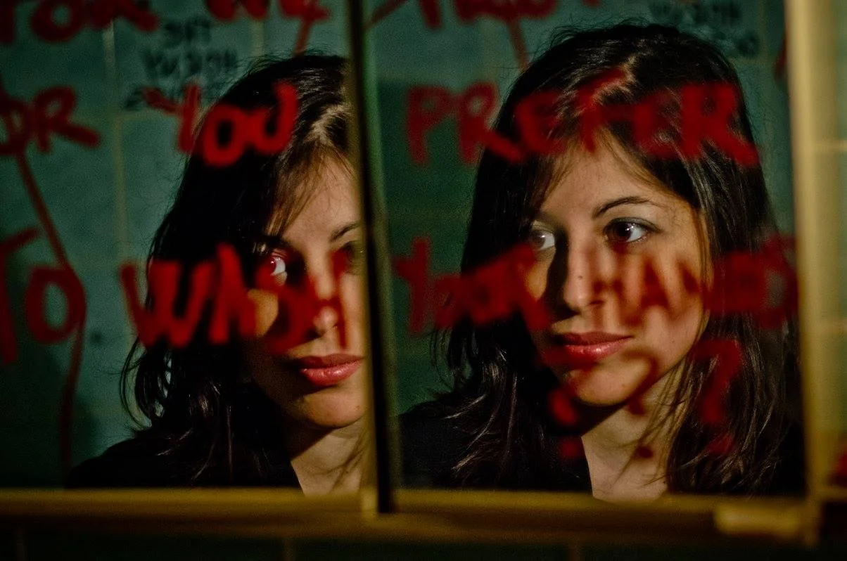 Il riflesso di Tiziana in uno specchio con scritte rosse