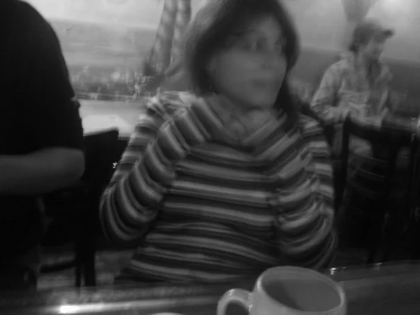 Tiziana a un tavolino di un caffè, foto in bianco e nero
