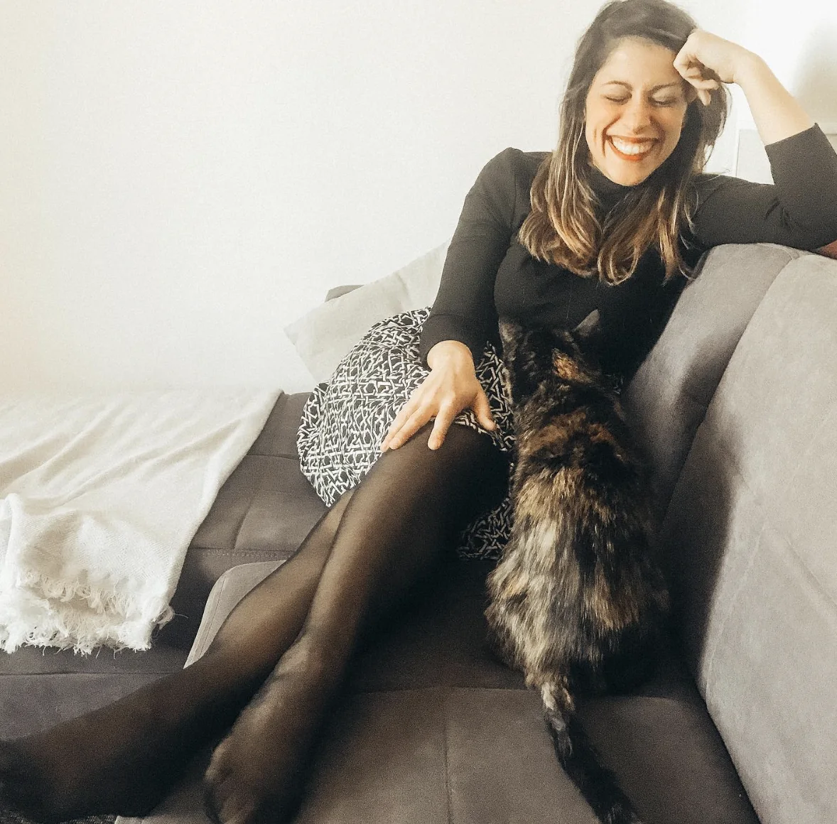 Tiziana ride sul divano con il suo gatto