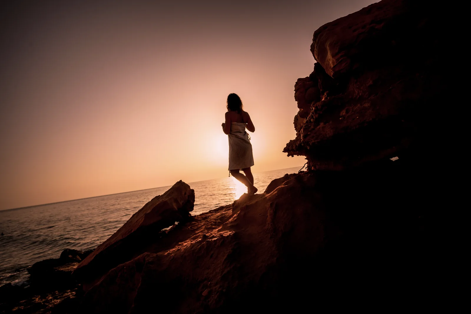 La silhouette di Tiziana sugli scogli al tramonto
